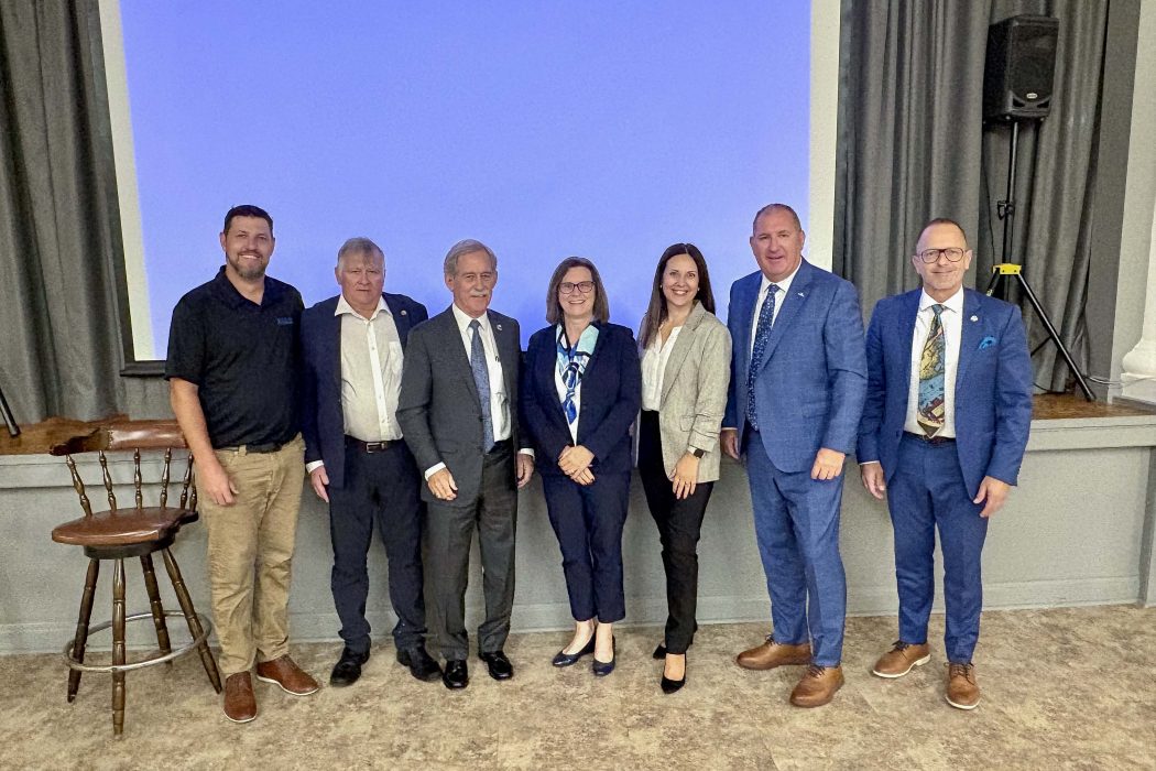 A group of people pose for a photo at a business event.