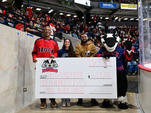 Three people and Boomer the Badger mascot stand holding a large check made out to the Brock University Students' Union's Food First program in the amount of $611.
