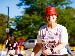 A woman in a red hat smiles while walking outside.