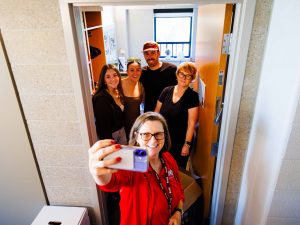 Five people pose for a selfie in a doorway.