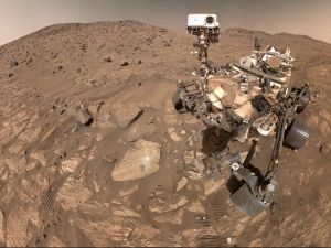 The dry, dusty, rocky surface of Mars is shown alongside the Perseverance rover, a robot able to terrain the Red Planet.