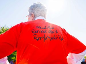 The back of a woman wearing an orange shirt.