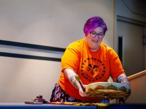 Woman holds drum at a table.