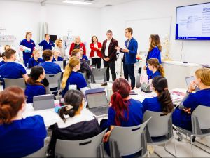 A man speaks to a group of nursing students.