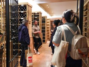 A group of people tour a wine cellar.