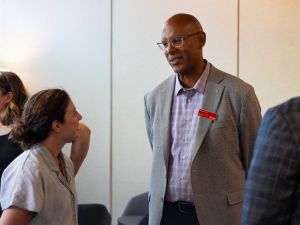 Man stands and talks with a woman in a meditation room.