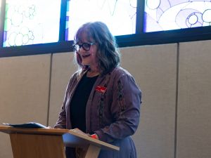 Woman talks at a podium in a meditation room.