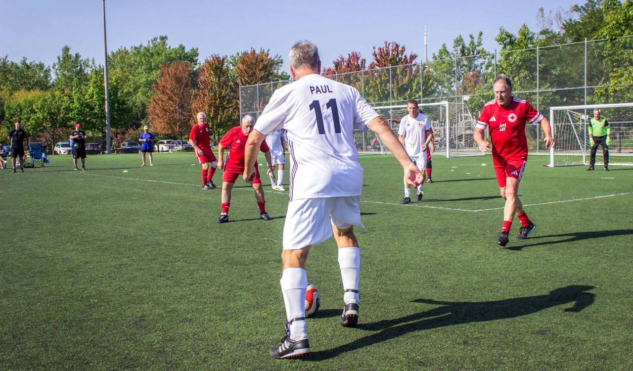 Men playing soccer on a sunny day.