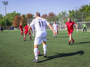 Men playing soccer on a sunny day.