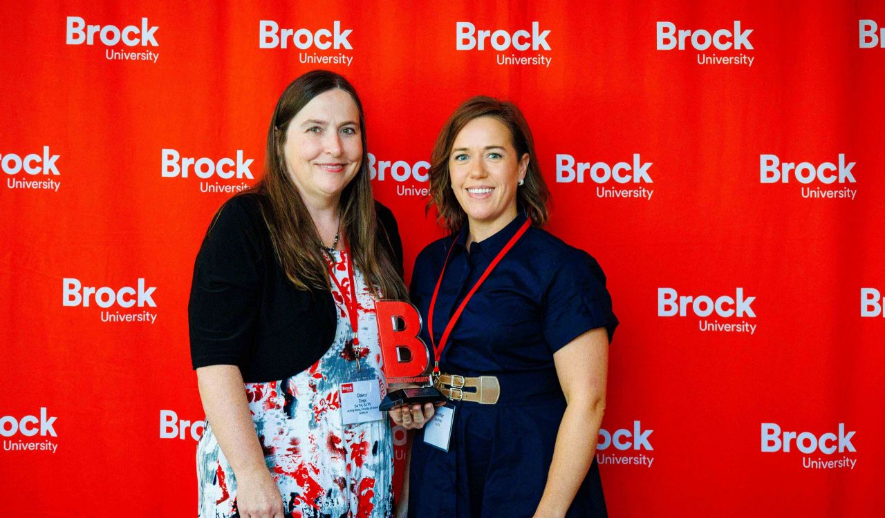 : Dawn Zinga and Jennifer Gauthier against red Brock-branded screen.