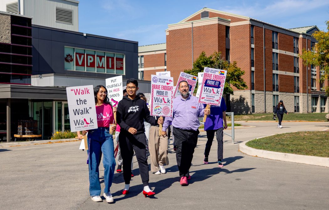 A group of people carry signs and participate in a fundraising walk.