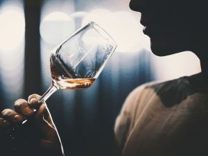 Close-up view of a person drinking a glass of wine.