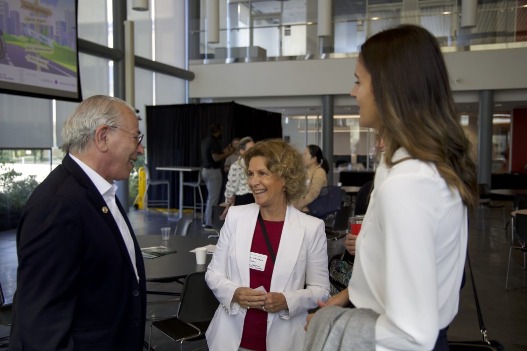 Three people having a conversation during a conference.