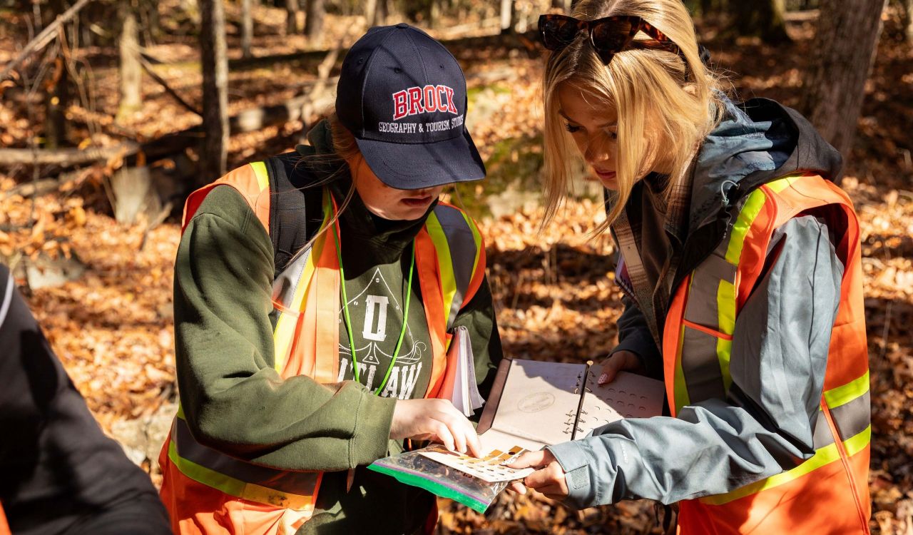 Sydney Westbury and Illiana Schlechta analyze soil in the forest.