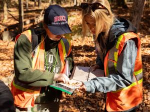 Sydney Westbury and Illiana Schlechta analyze soil in the forest.