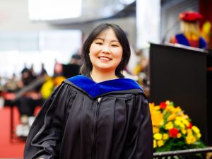 Yanan Liu (MBA '25) crosses the stage at Fall Convocation in Ian Beddis Gymnasium on Friday, Oct. 17.