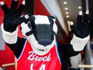 The Brock Badger mascot waves enthusiastically toward the camera.