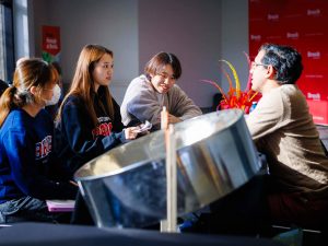 Four people talk at a table during an event.