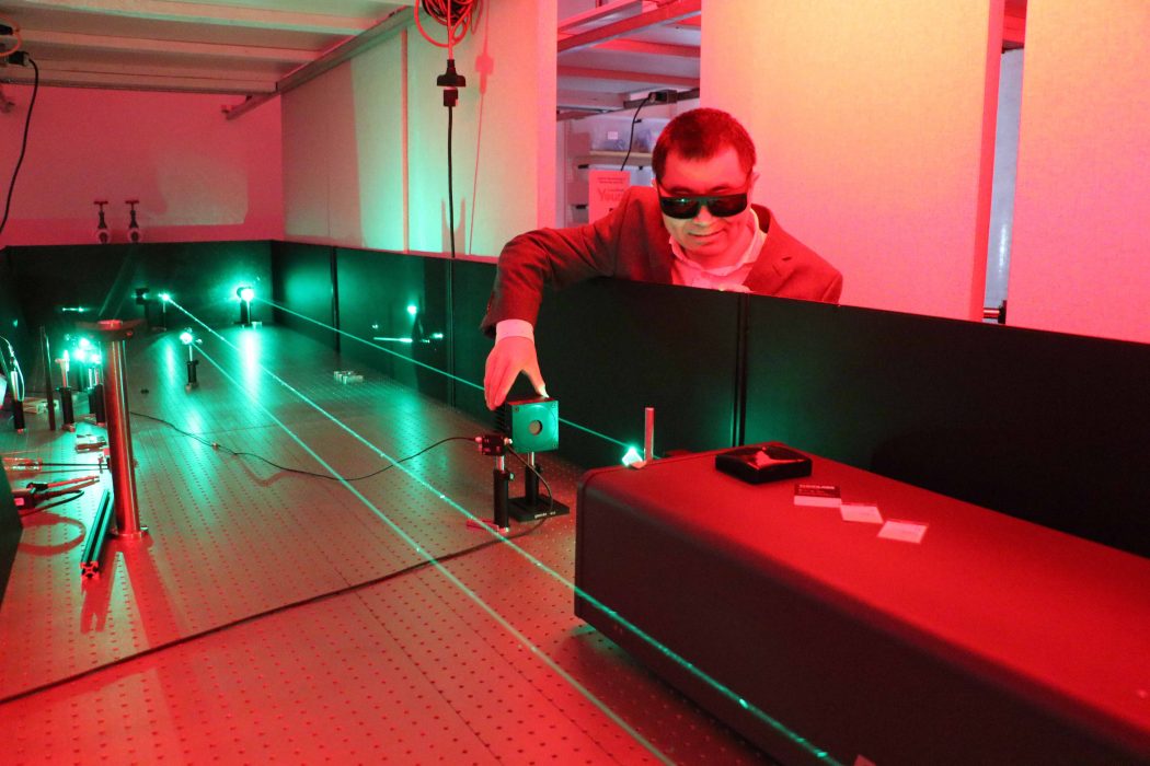 A man uses a laser machine in a university research lab.
