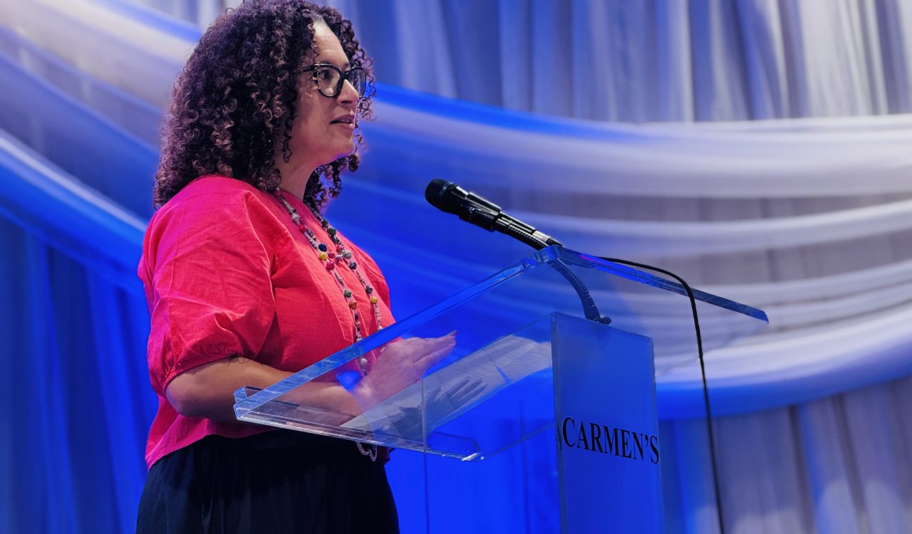 A woman stands at a podium giving a speech.
