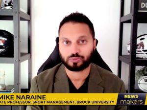 A screenshot of a man speaking during a news broadcast.