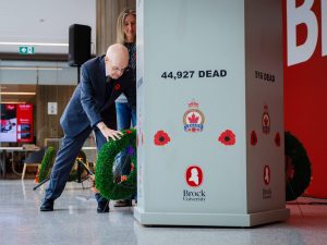 A man places a wreath at a cenotaph during a Remembrance Day ceremony.