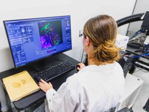A woman sits in front of a laptop working on research.