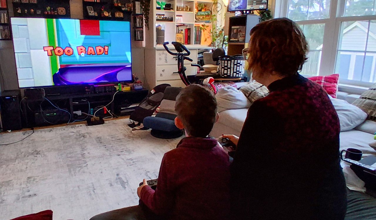 A woman plays video games with her son.