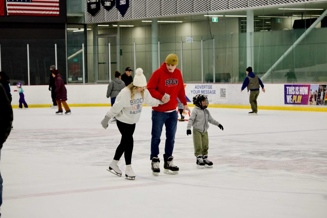 Two adults skate with a child.