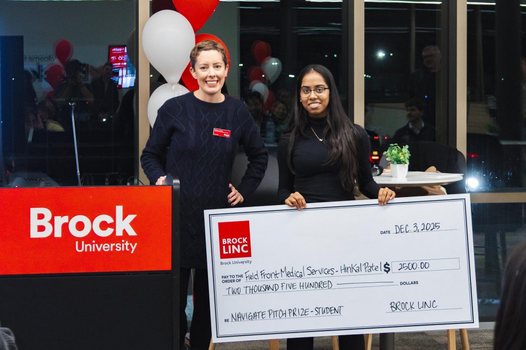 Two women pose with a giant cheque.