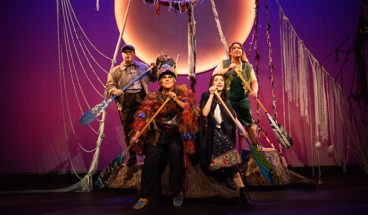 Four people perform a play on stage.