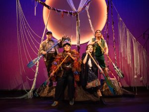 Four people perform a play on stage.