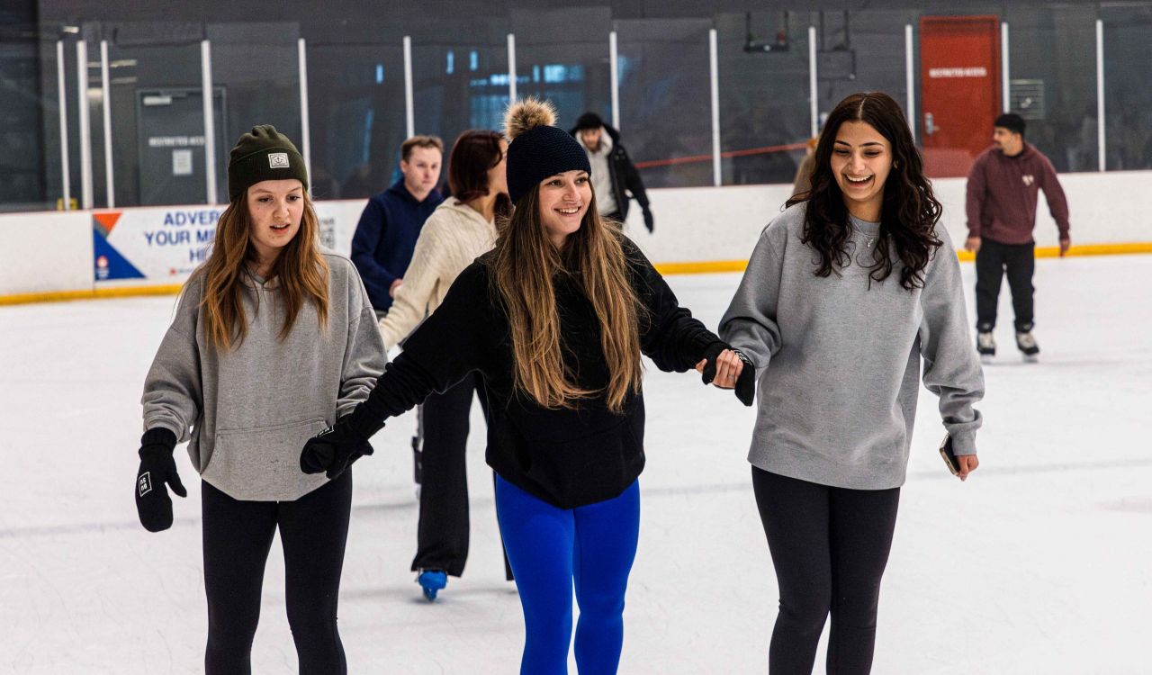 University students skating at an ice rink.