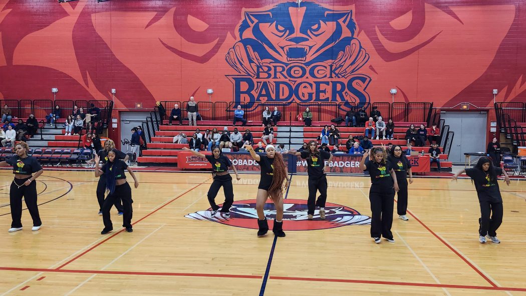 Group of female dancers perform in a gymnasiuyn