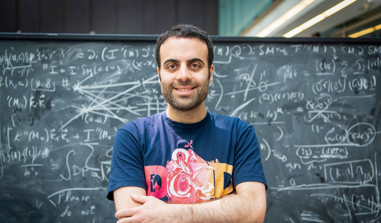 A man stands in front of a chalkboard.