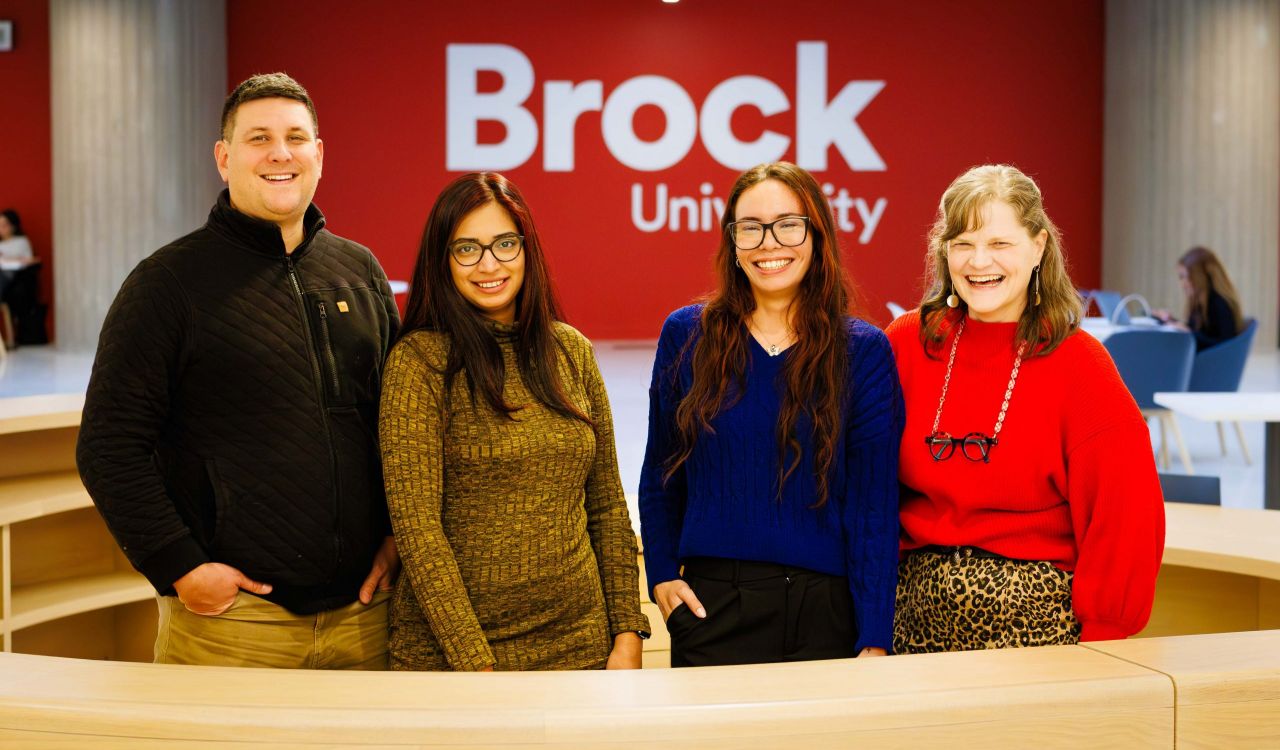 Employees of Brock University stand at a desk at the front of the Rankin Family Pavilion. (Photo by Stephen Leithwood)