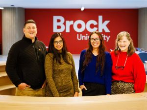 Employees of Brock University stand at a desk at the front of the Rankin Family Pavilion. (Photo by Stephen Leithwood)