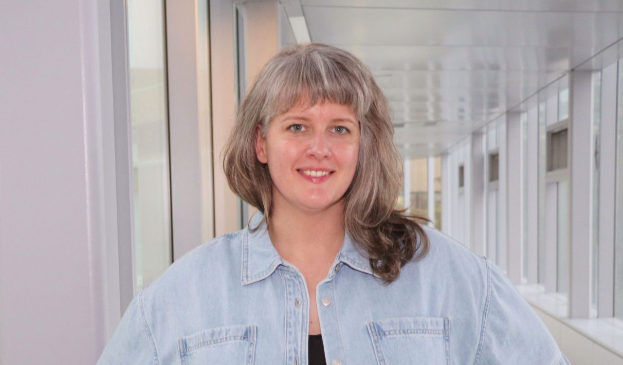 Portrait photo of Chelsea Jones standing in a hallway.