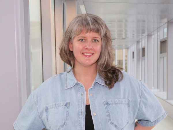 Portrait photo of Chelsea Jones standing in a hallway.