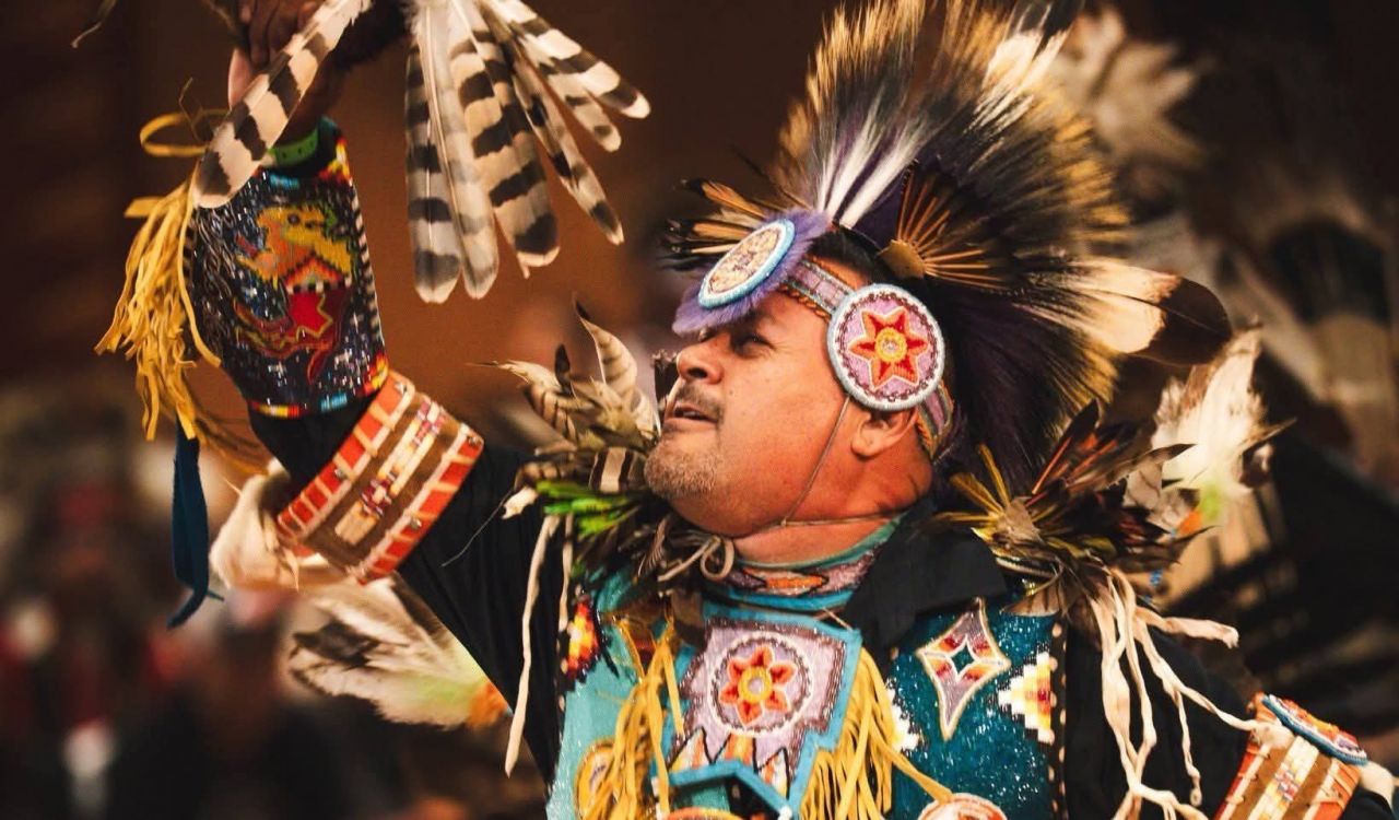 Close-up of a man dancing in Indigenous regalia.