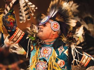 Close-up of a man dancing in Indigenous regalia.