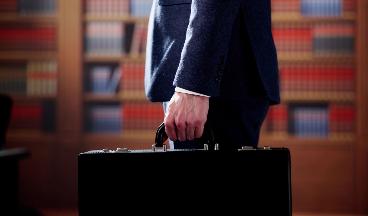 Close-up of a briefcase held by a person in a business suit.