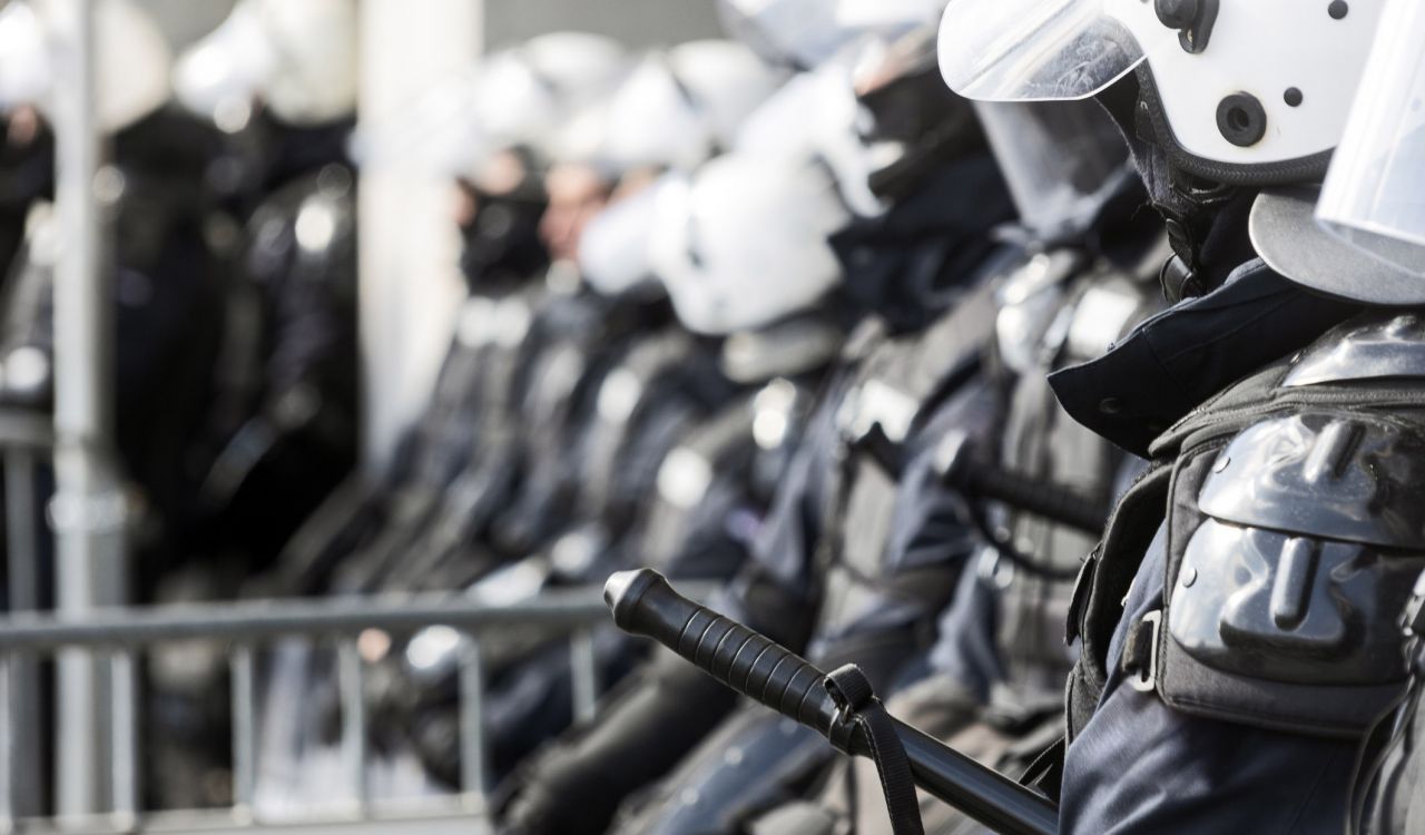 Close-up view of police officers standing in a line in riot gear.