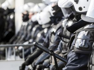 Close-up view of police officers standing in a line in riot gear.