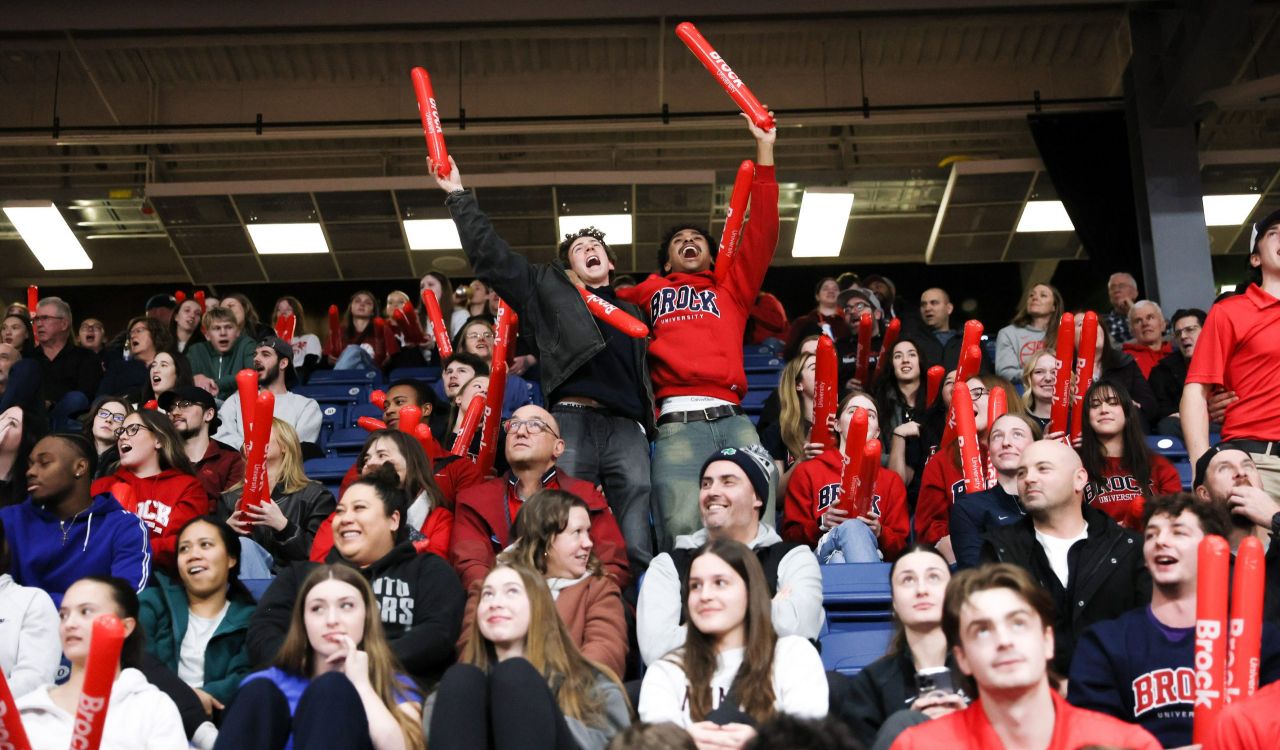 A crowd cheers at a university basketball game.