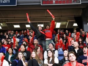 A crowd cheers at a university basketball game.
