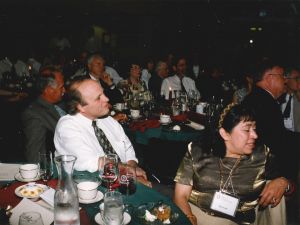 Two people sit at a table in a banquet hall.