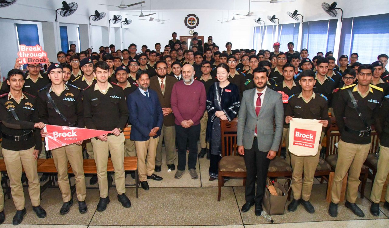 A large group of people pose for a photo inside a high school.