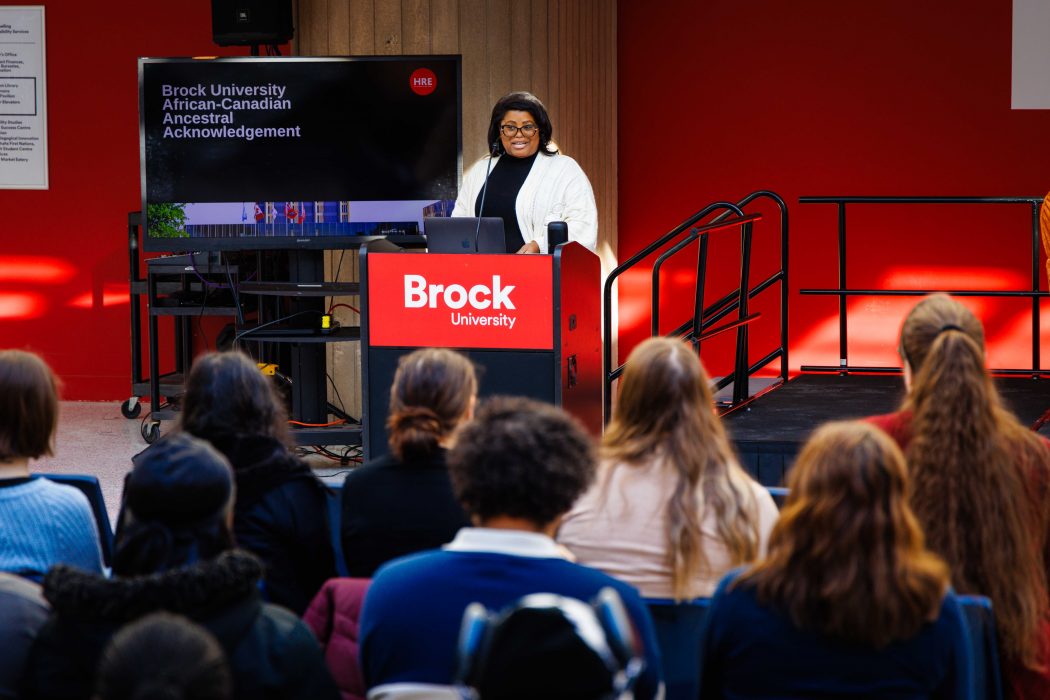 A woman speaks to an audience while standing at a podium.