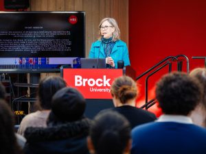 A woman speaks to an audience while standing at a podium.